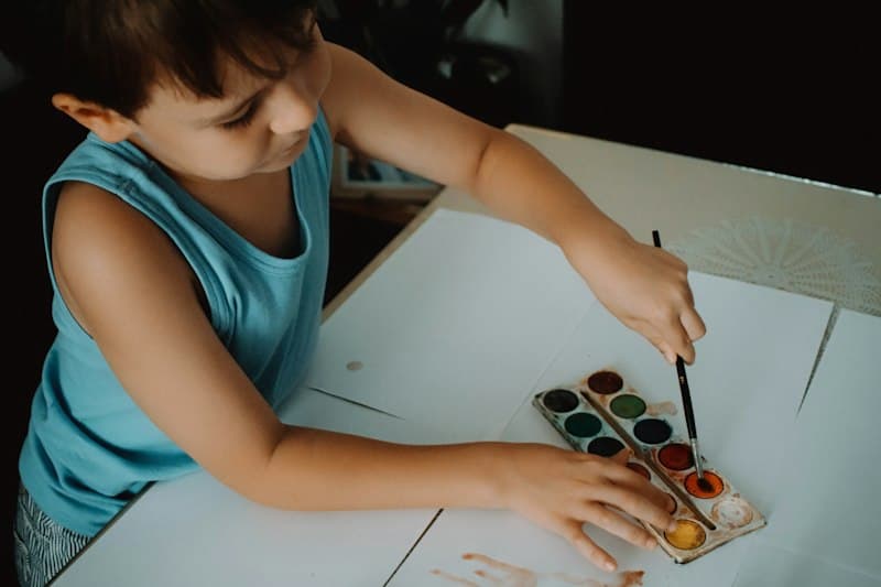 طفل يرسم بالألوان المائية